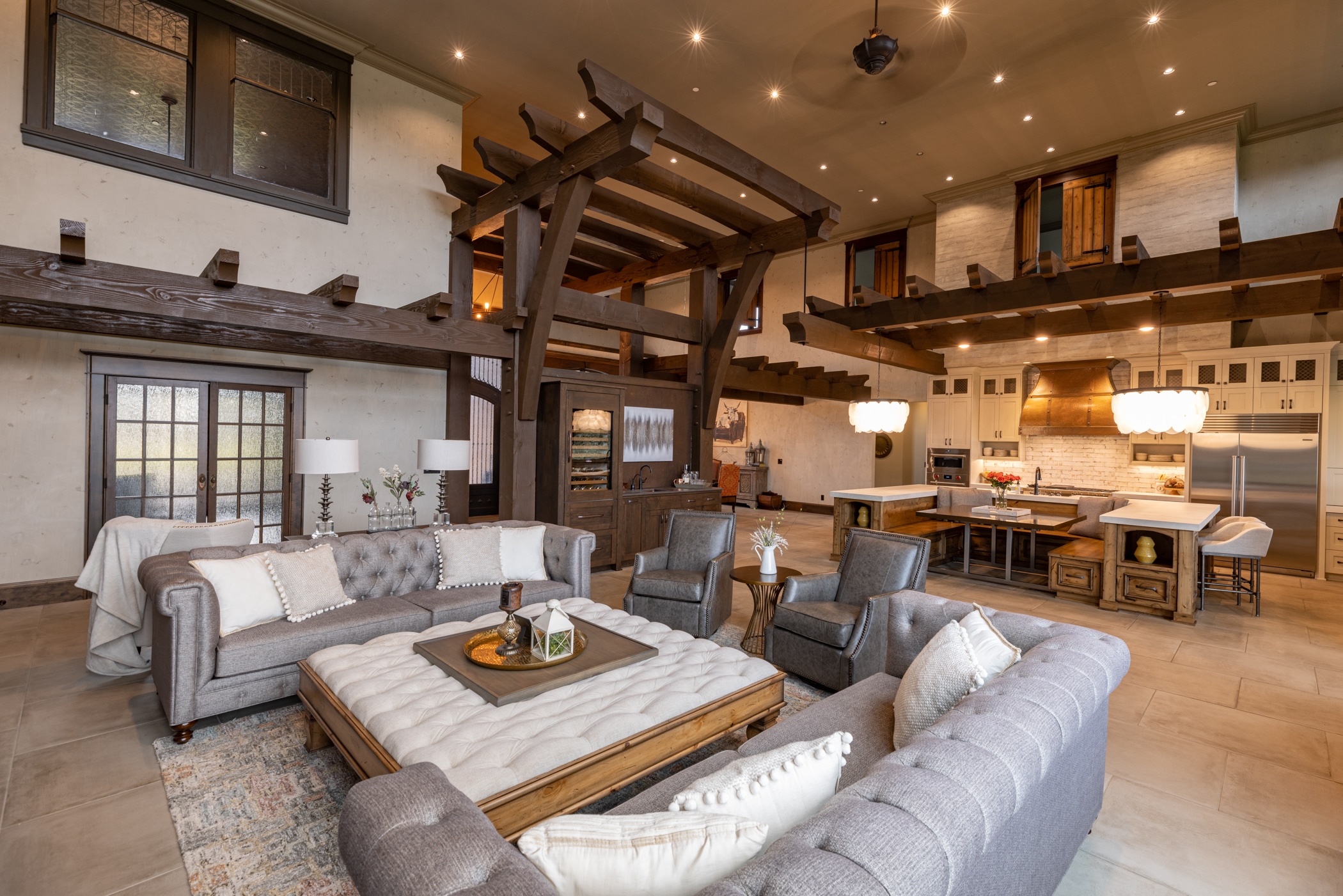 This hybrid timber frame home featured brick & timbers on the exterior. The inside of this home is most unique. With 25 foot high ceilings in the Great Room, the timbers create a ceiling feel without enclosing the space. More brick is also featured on the fireplace. The timbers have a darker stain that contrasts against the white walls. Most noteworthy is the door selection, which are all selected from older buildings. Each door was chosen before the floor plans were complete. Even doors from a rodeo were incorporated into the main area of this home. The timber package is a hybrid timber frame kit explicitly designed for this floor plan. Enjoy the distinctive design and look of this gorgeous Mediterranean Hybrid Timber Frame Home.